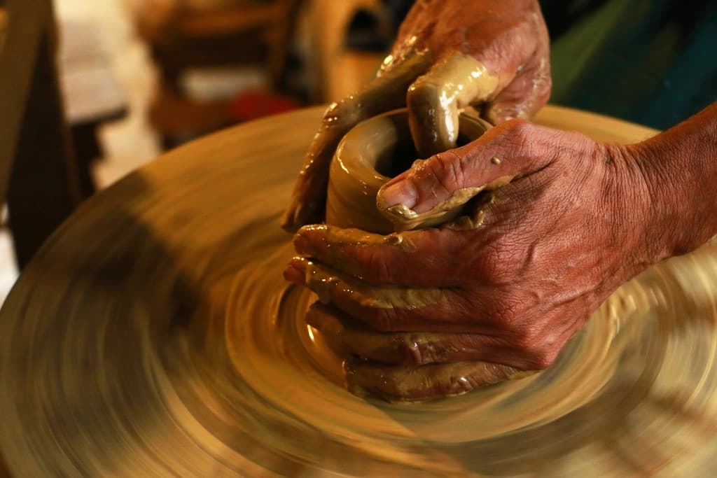 Mains façonnant l’argile sur un tour de potier